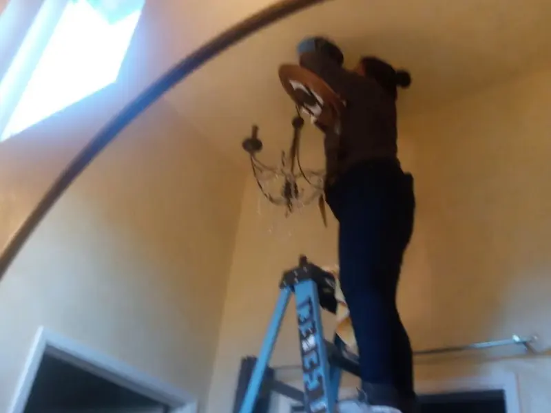 Electrician installing a chandelier in a Lithopolis residence